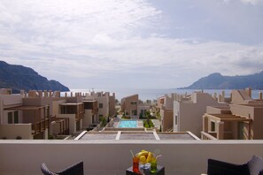 Un complexe hôtelier doté d’une piscine, de plusieurs bâtiments et offrant une vue sur la mer.