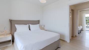 Un dormitorio moderno con una cama grande, mesitas de noche y una lámpara en el techo.