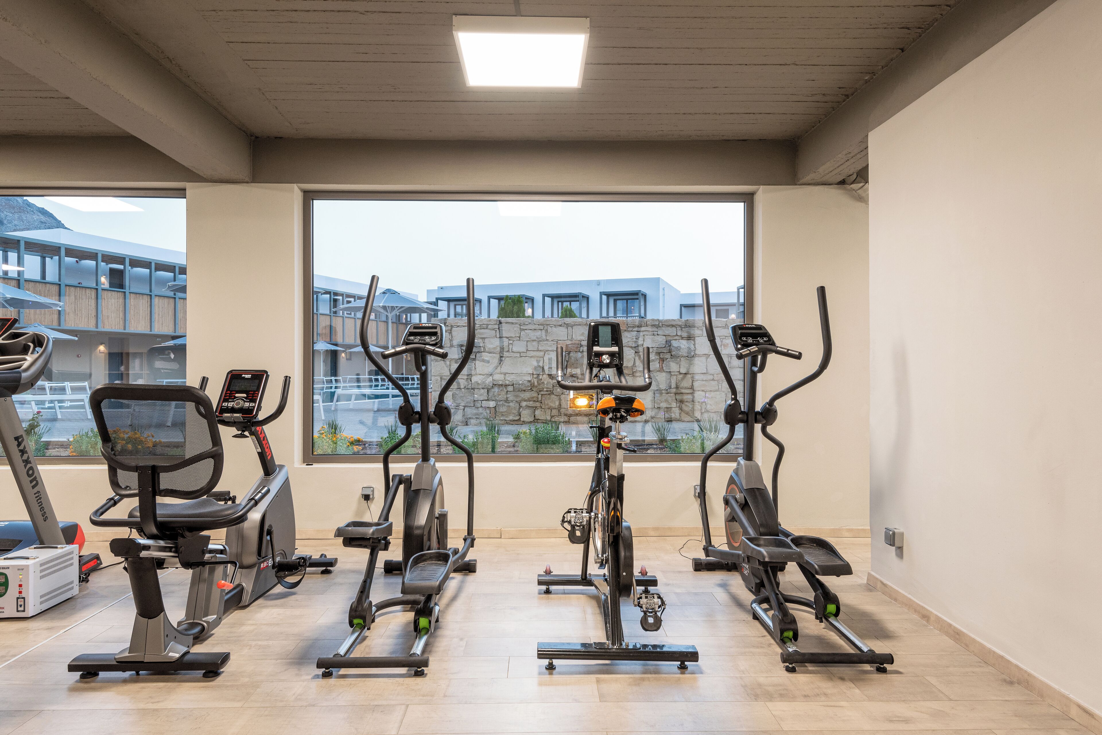 A gym with four stationary bikes, a treadmill, and a rowing machine.