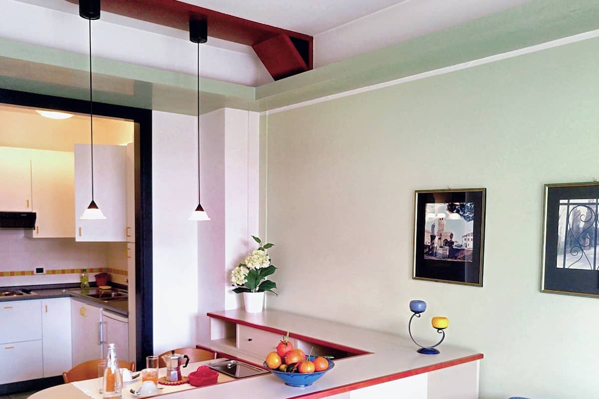 Une cuisine compacte avec un îlot central, un coin repas avec une table et des chaises, et un espace salon avec un canapé.