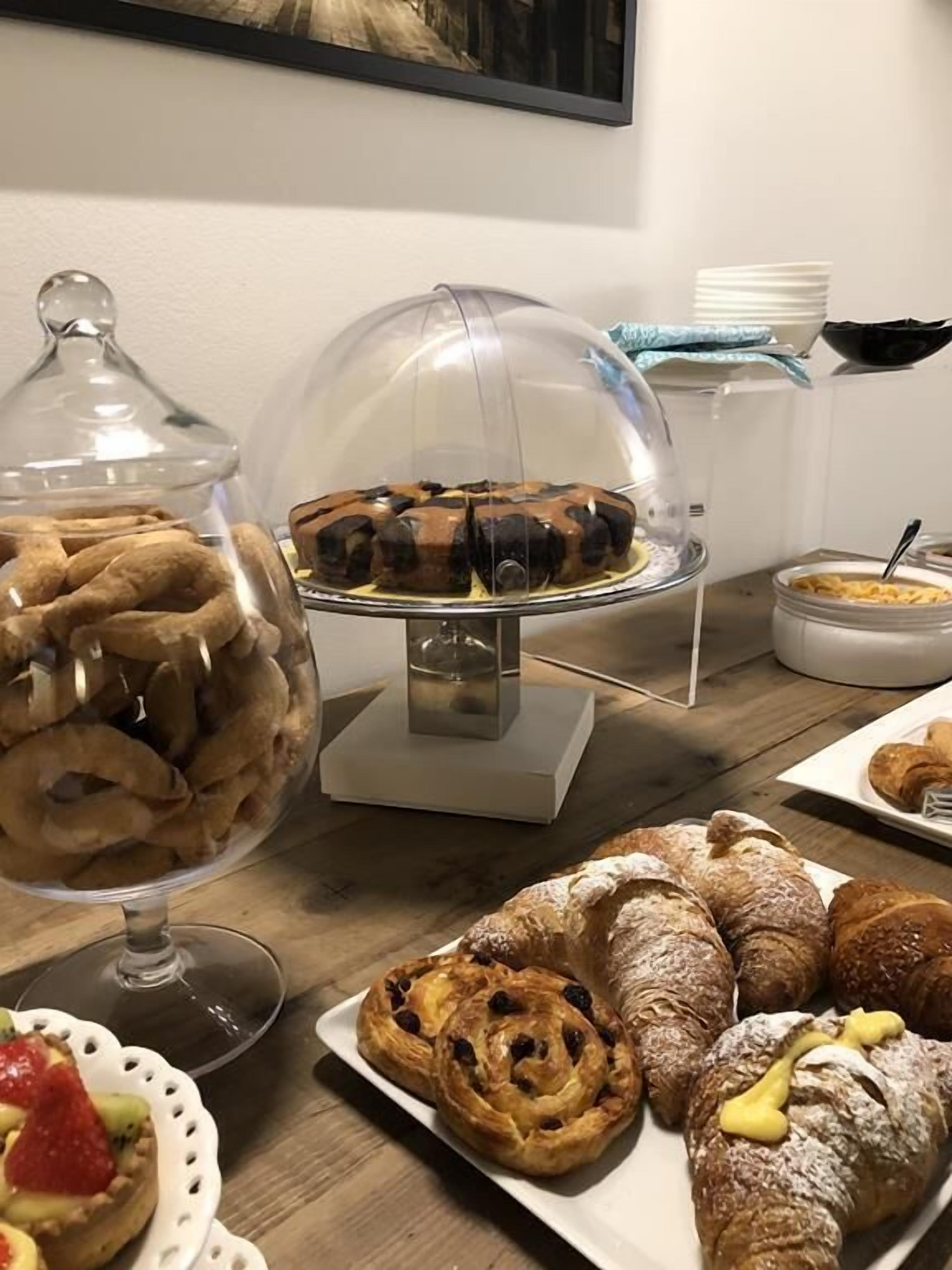 Ein reich gedeckter Büfett mit verschiedenen Gebäcken und Desserts, darunter eine Kuchenplatte und eine Obstschale.