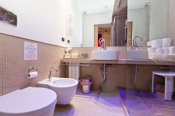 Une salle de bain avec deux lavabos, un miroir et des toilettes.