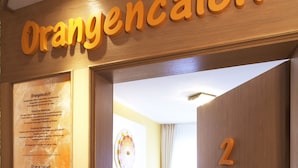 Un letrero de madera con el texto "Orangencalcium" y el número "2" en una pared.