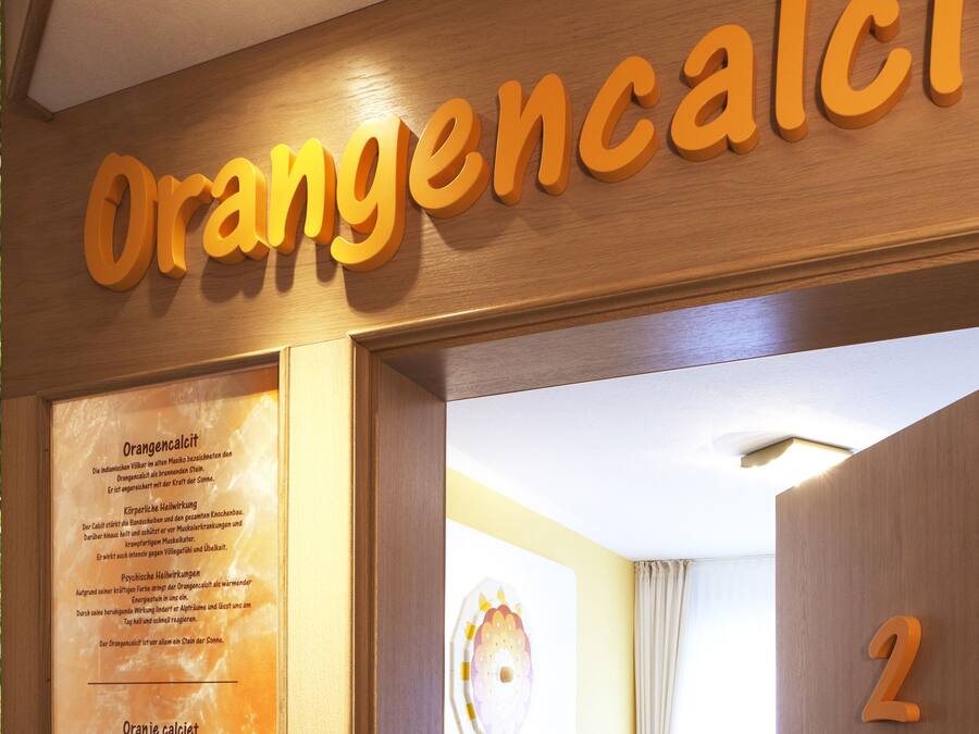 A wooden sign with the text "Orangencalcium" and a number "2" on a wall.