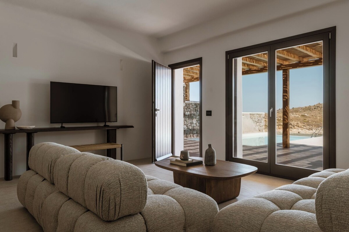 Un salon moderne avec un téléviseur à écran plat, un canapé et une table basse.