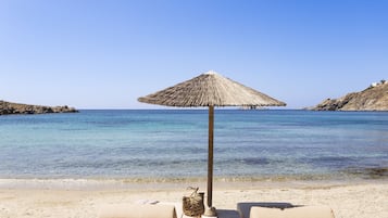 En privat strand, liggestole, parasoller, badehåndklæder