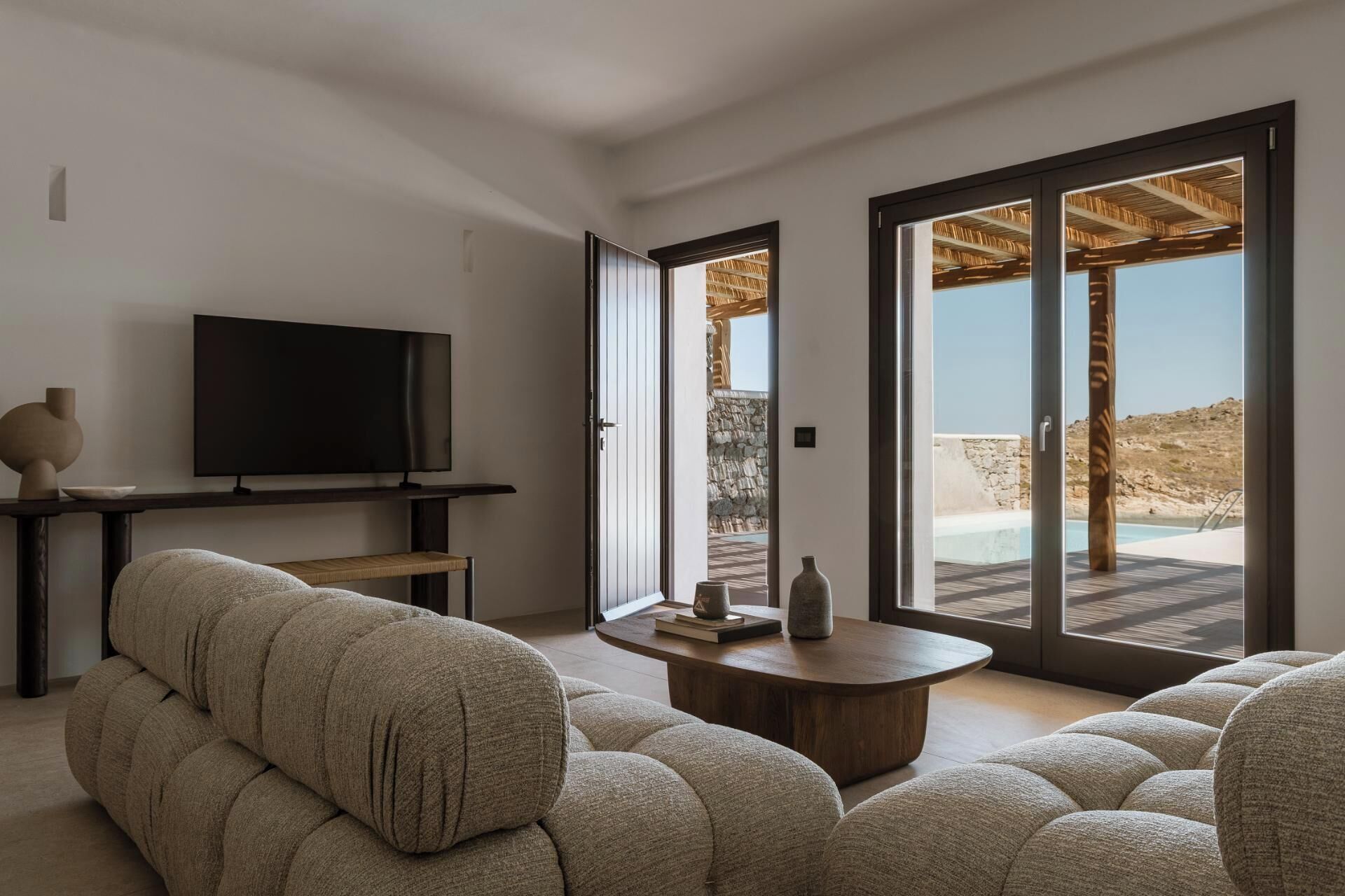 Una sala de estar moderna con una televisión de pantalla plana, un sofá y una mesa de centro.