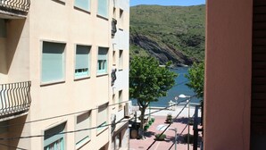 Un edificio con varios balcones que dan a la costa, con vistas al mar y colinas.