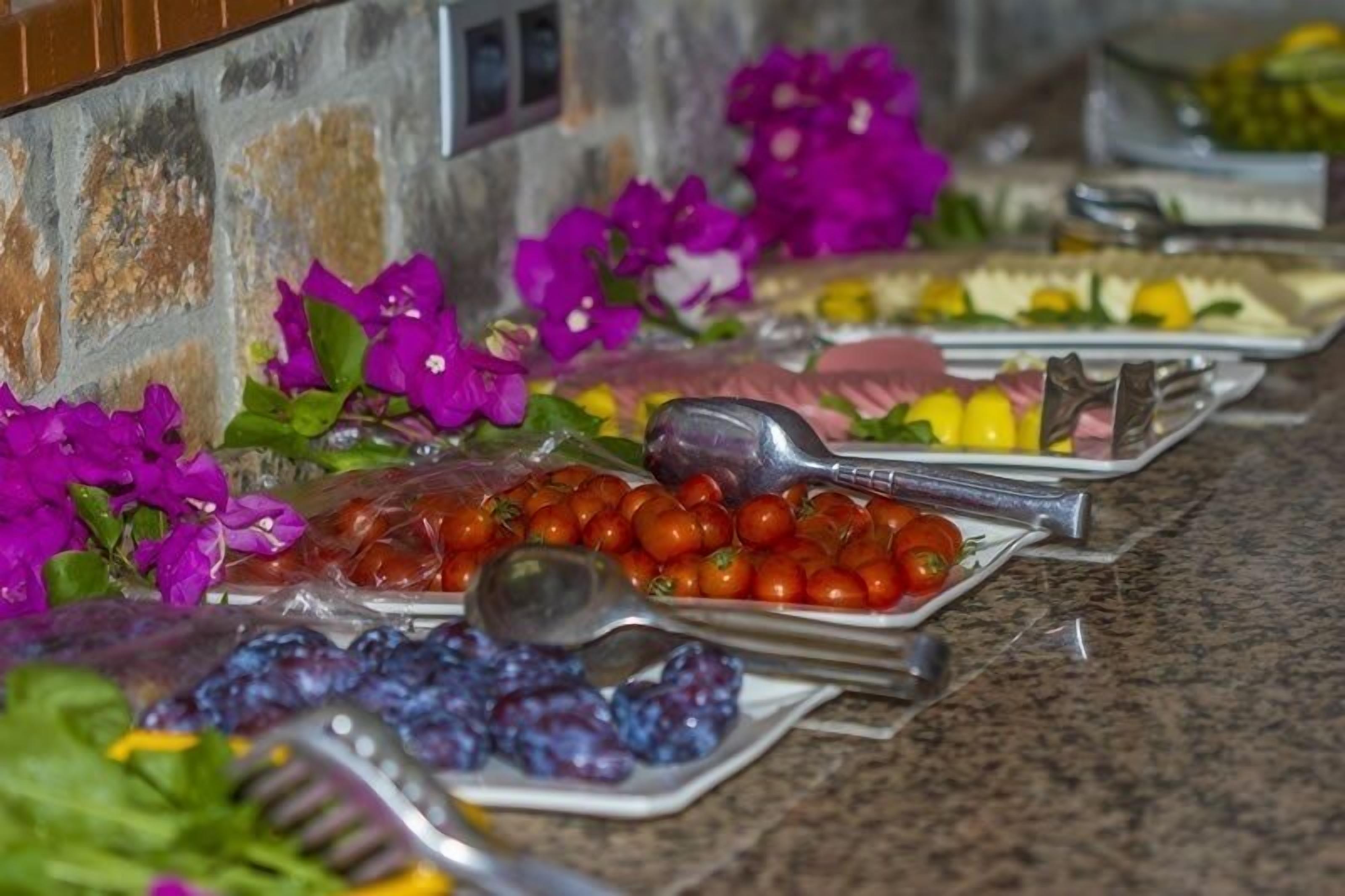 A buffet table with various food items and utensils.
