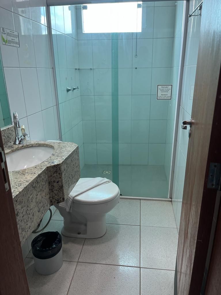 A bathroom with a shower, toilet, and sink.