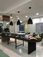 Una cocina moderna con una isla central, iluminación colgante y una zona de buffet.