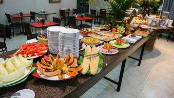 Uma mesa de buffet com diversos alimentos e utensílios.