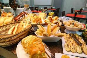 Un bufé con panes y pastelería variada.