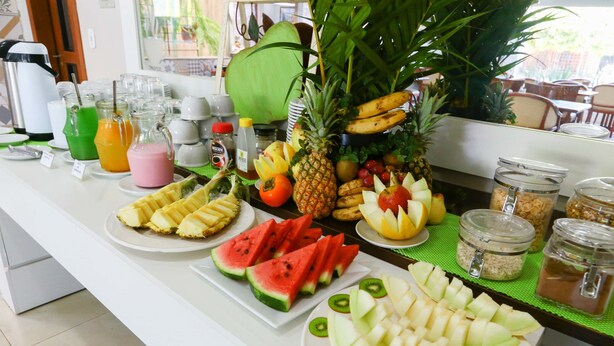 A breakfast buffet with various fruits, juices, and condiments. - Ecos Conforto (Porto Velho)