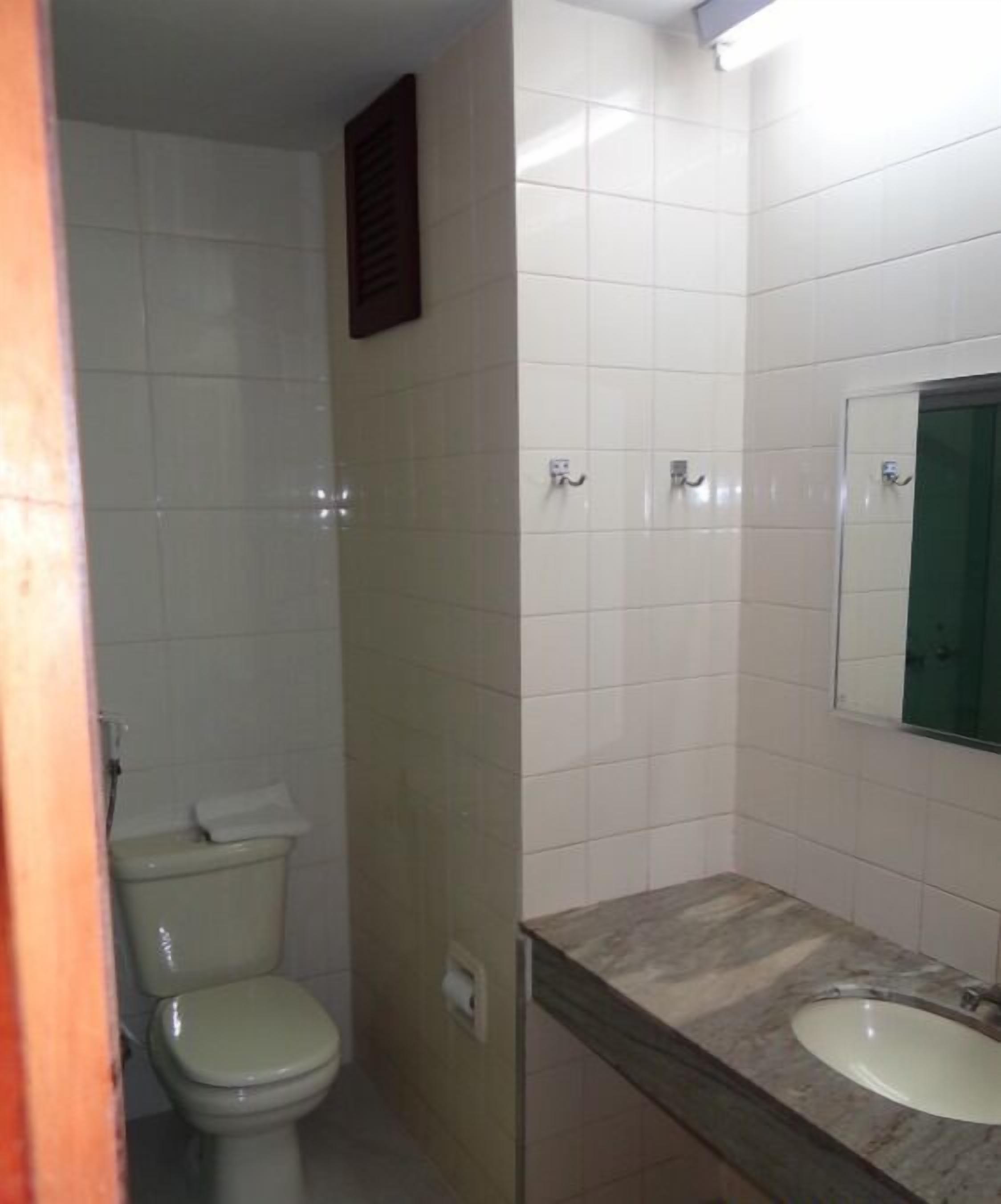 Ein kleines Badezimmer mit Toilette, Waschbecken und Spiegel.