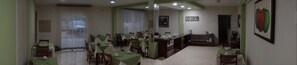 A dining area with multiple tables and chairs, a counter, and a framed picture on the wall. - Ecos Hotel Tourist (Rolim de Moura)