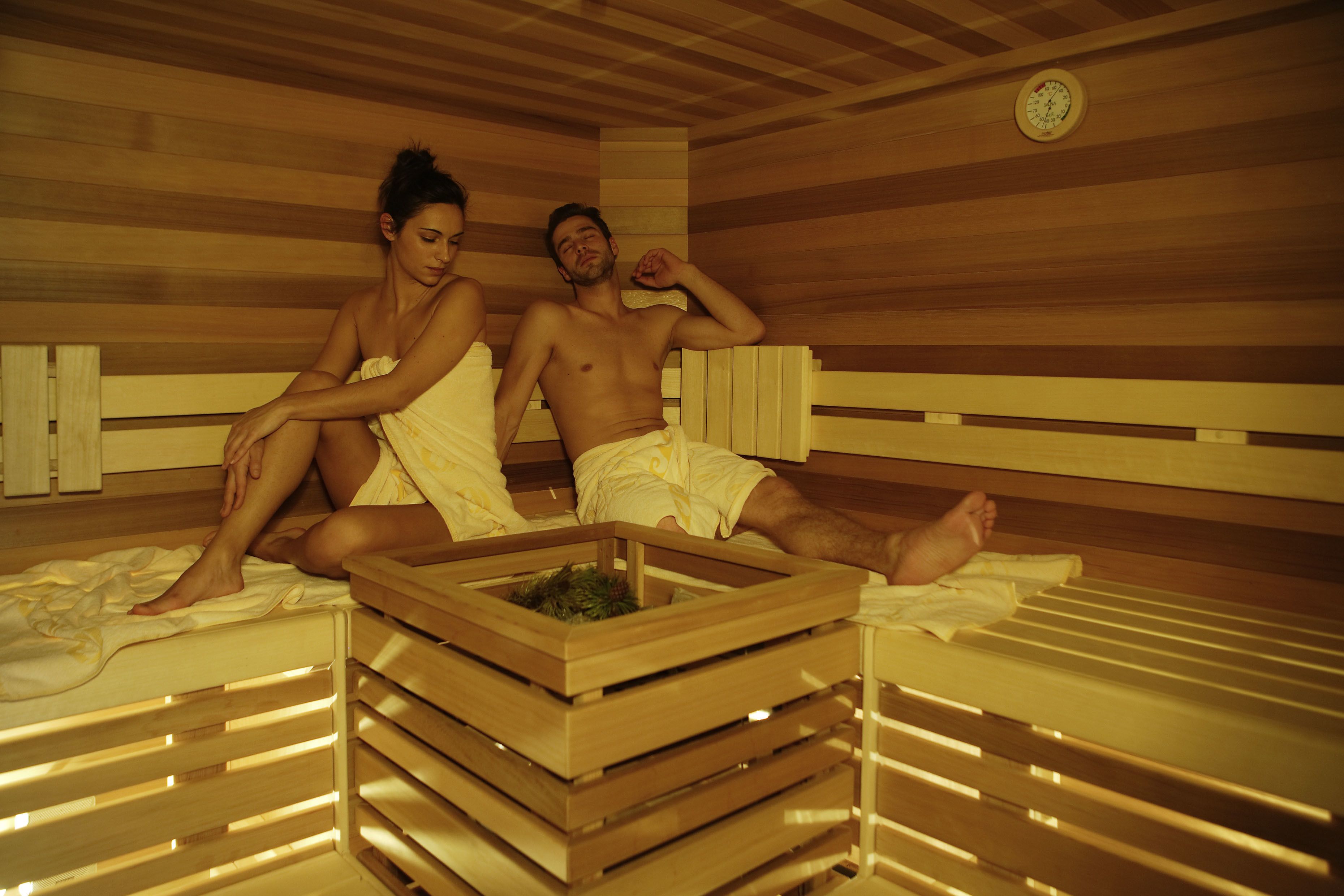 Una sauna con panche in legno e un elemento riscaldante centrale.
