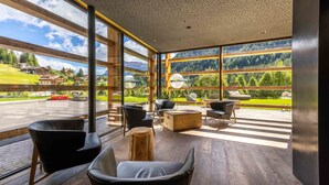 A spacious indoor area with large windows offering a view of a mountainous landscape.