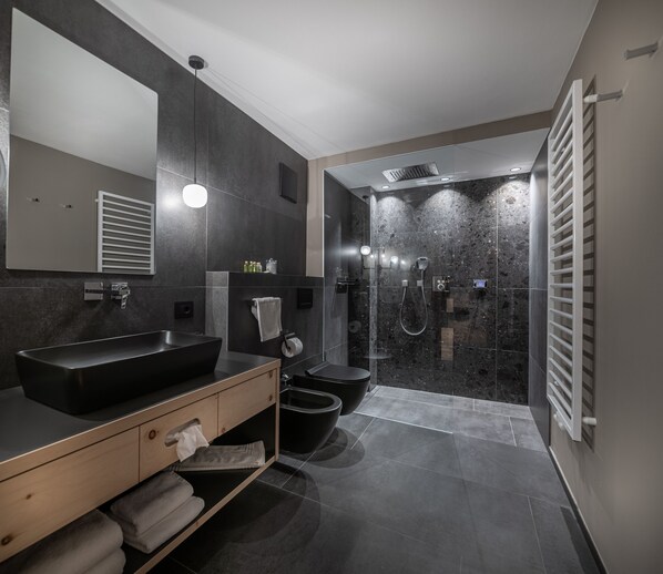 Un baño moderno con un lavamanos grande, un espejo y una ducha a ras de suelo.
