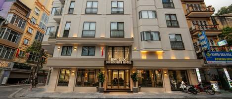 A multi-story hotel with a prominent entrance, balconies, and signage for the Hong Ngoc Cochinchine Hotel.