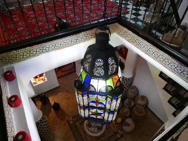 A room with a patterned floor, a decorative lantern, and a red rug. - Dar Sultan (Tangier)