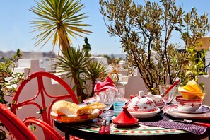 A table set for a meal with plates, glasses, and a red chair.