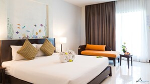 Une chambre d’hôtel avec un grand lit, un canapé, une petite table avec une plante et un tableau au mur.