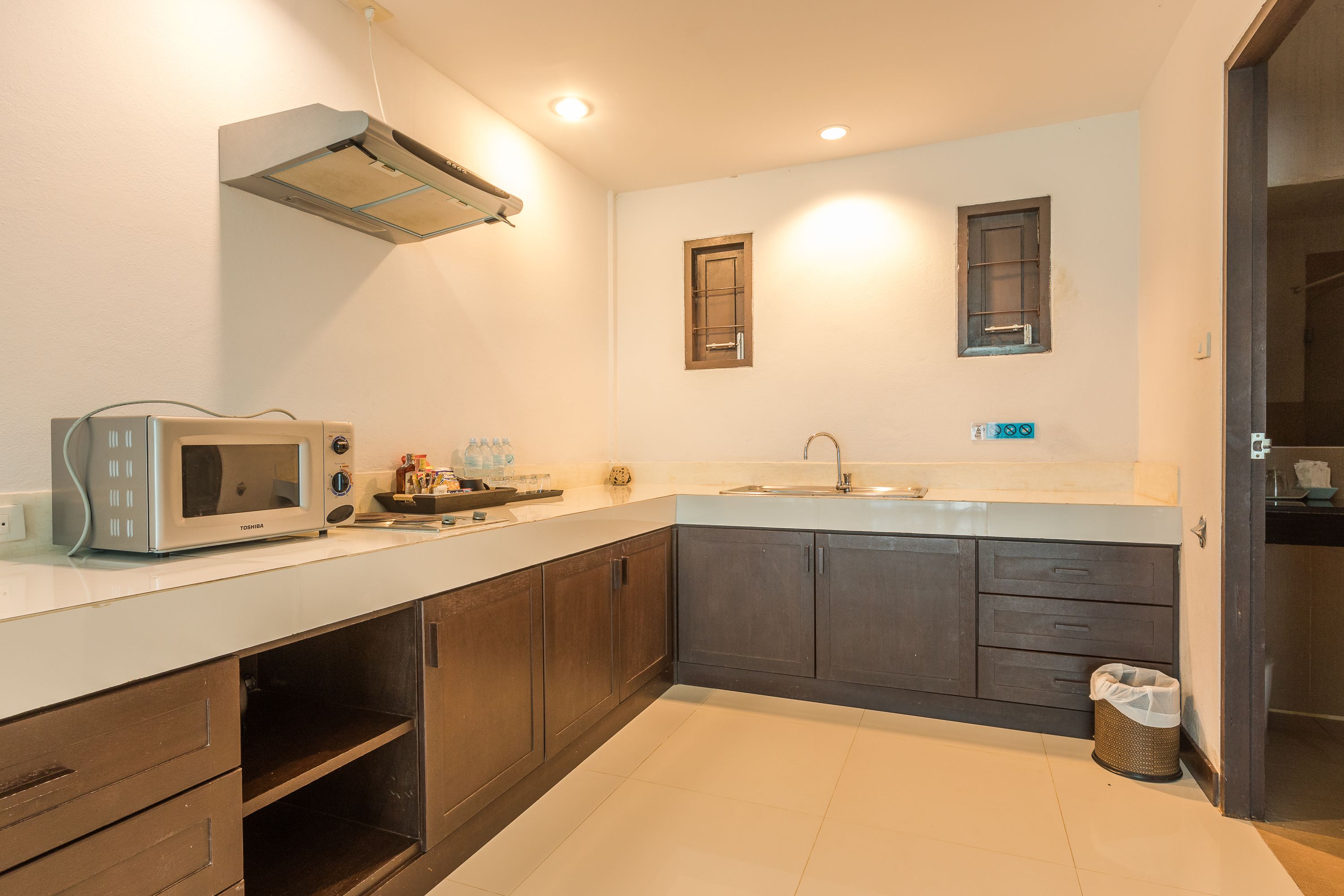 A modern kitchen with a microwave, cabinets, and a sink.