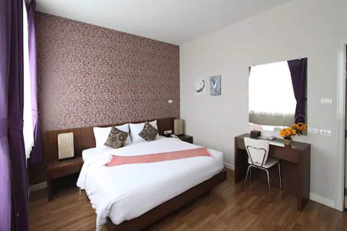 Une chambre avec un grand lit, un bureau et une chaise.