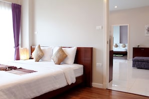 A hotel room with a large bed, a wooden headboard, and a view of the hallway. - Baiyoke Ciao Hotel (Chiang Mai)