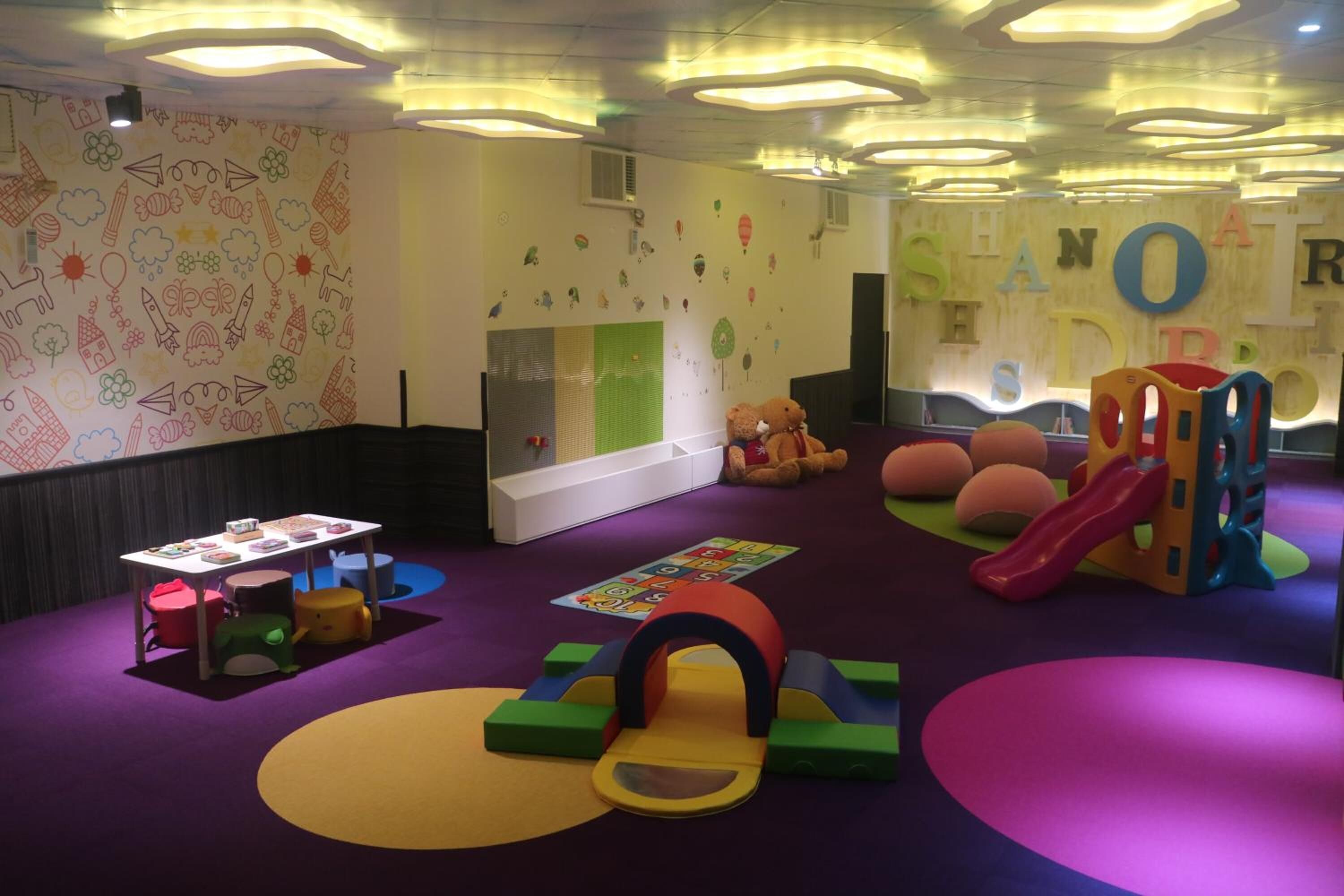 Un área de juegos infantiles con juguetes coloridos y un tobogán.