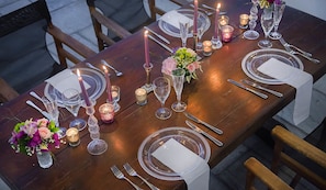 A beautifully set dining table with candles, flowers, and fine china.