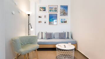 A modern living room with a sofa, a round coffee table, a chair, and a floor lamp.