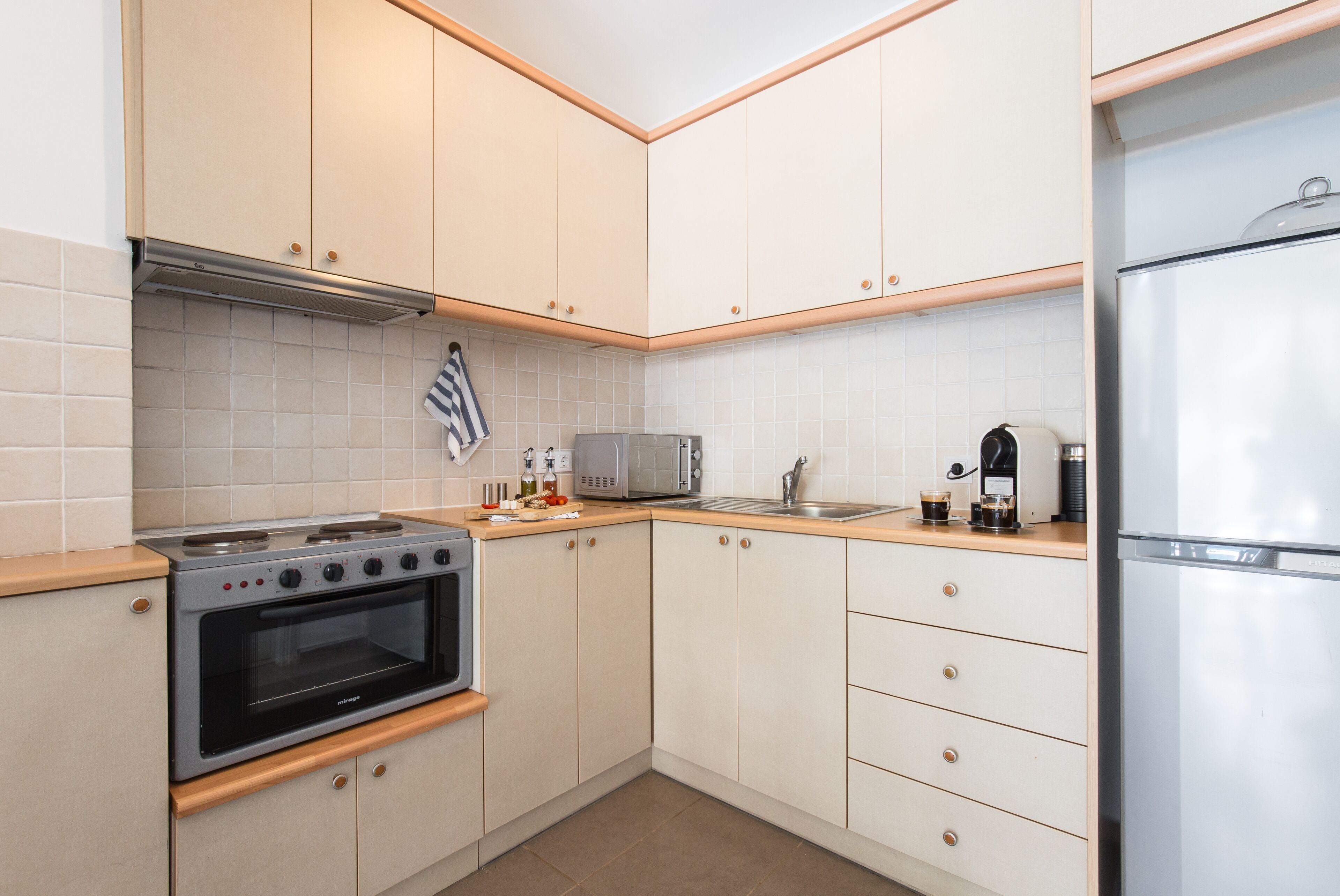 A modern kitchen with a built-in oven, microwave, and refrigerator.