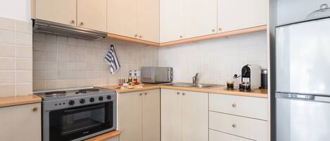 A modern kitchen with a built-in oven, microwave, and refrigerator.