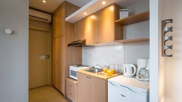 A modern kitchen with wooden cabinets, a white countertop, a built-in oven, and a coffee maker.