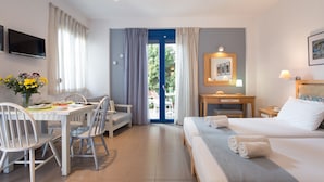 Une chambre d’hôtel équipée d’un lit, d’un bureau, d’une chaise, d’une télévision et offrant une vue sur l’extérieur.