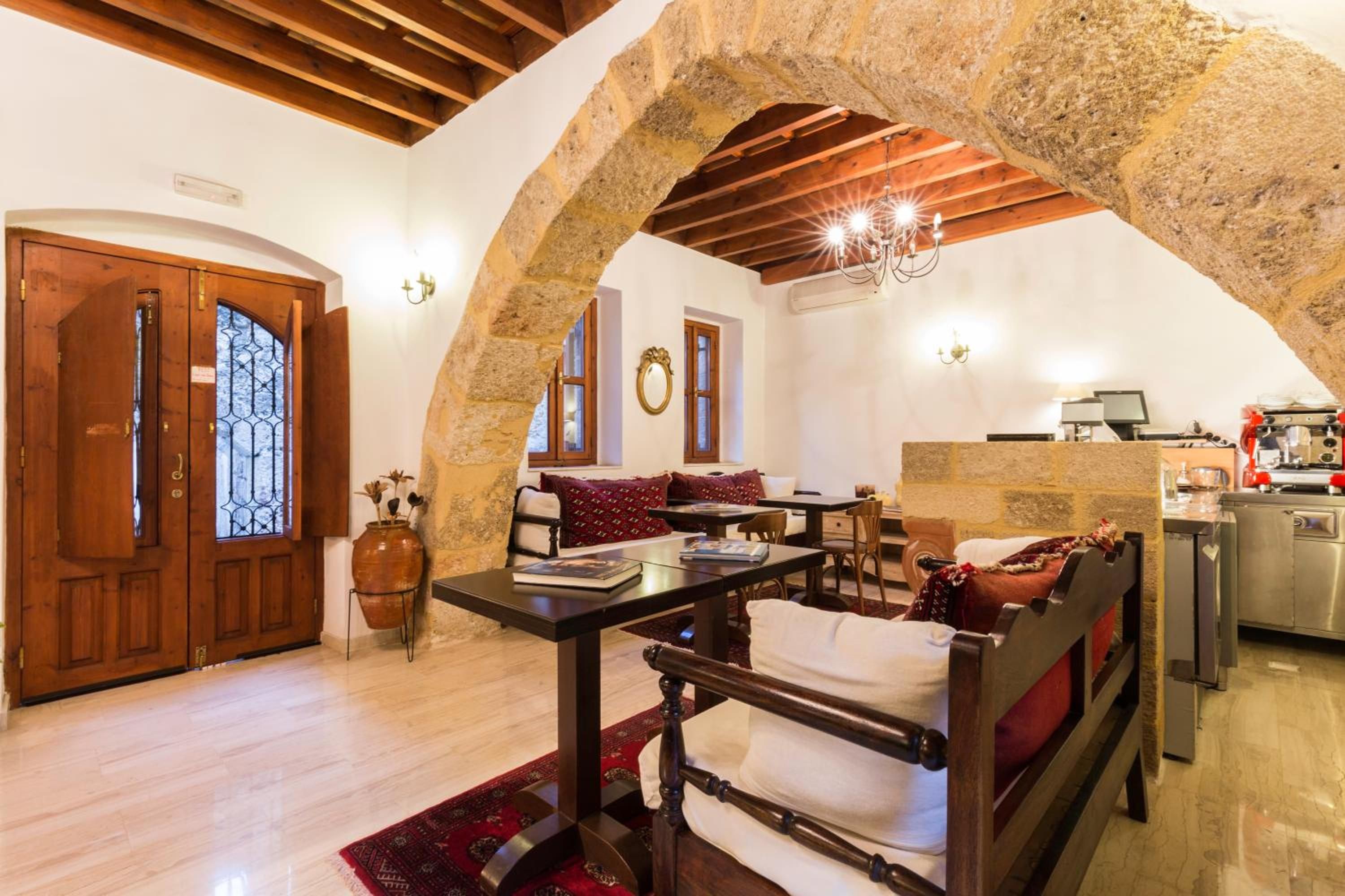 A rustic interior with a stone archway, wooden furniture, and a kitchen area.