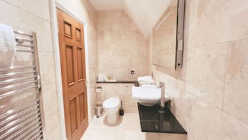 Un baño pequeño con inodoro, lavamanos y barra para toallas.