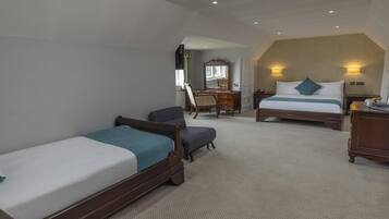 Habitación de hotel con dos camas individuales, un escritorio con silla, cómoda y espejo.