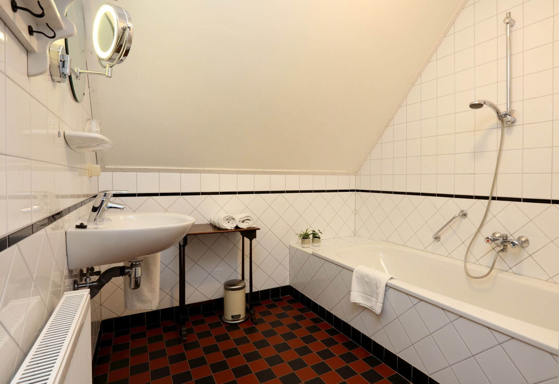 A bathroom with a sink, mirror, and shower.