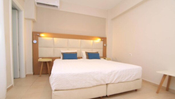Un dormitorio con una cama grande, una mesita de noche y un velador.