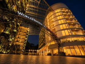 Un hotel con un llamativo letrero de 'WorldHotels', diseño arquitectónico moderno y un área de entrada bien iluminada.