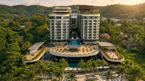 A resort with a pool, sun loungers, and a beach.