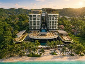 A resort with a pool, sun loungers, and a beach. - WorldHotels Long Beach Resort Phu Quoc (Phu Quoc)