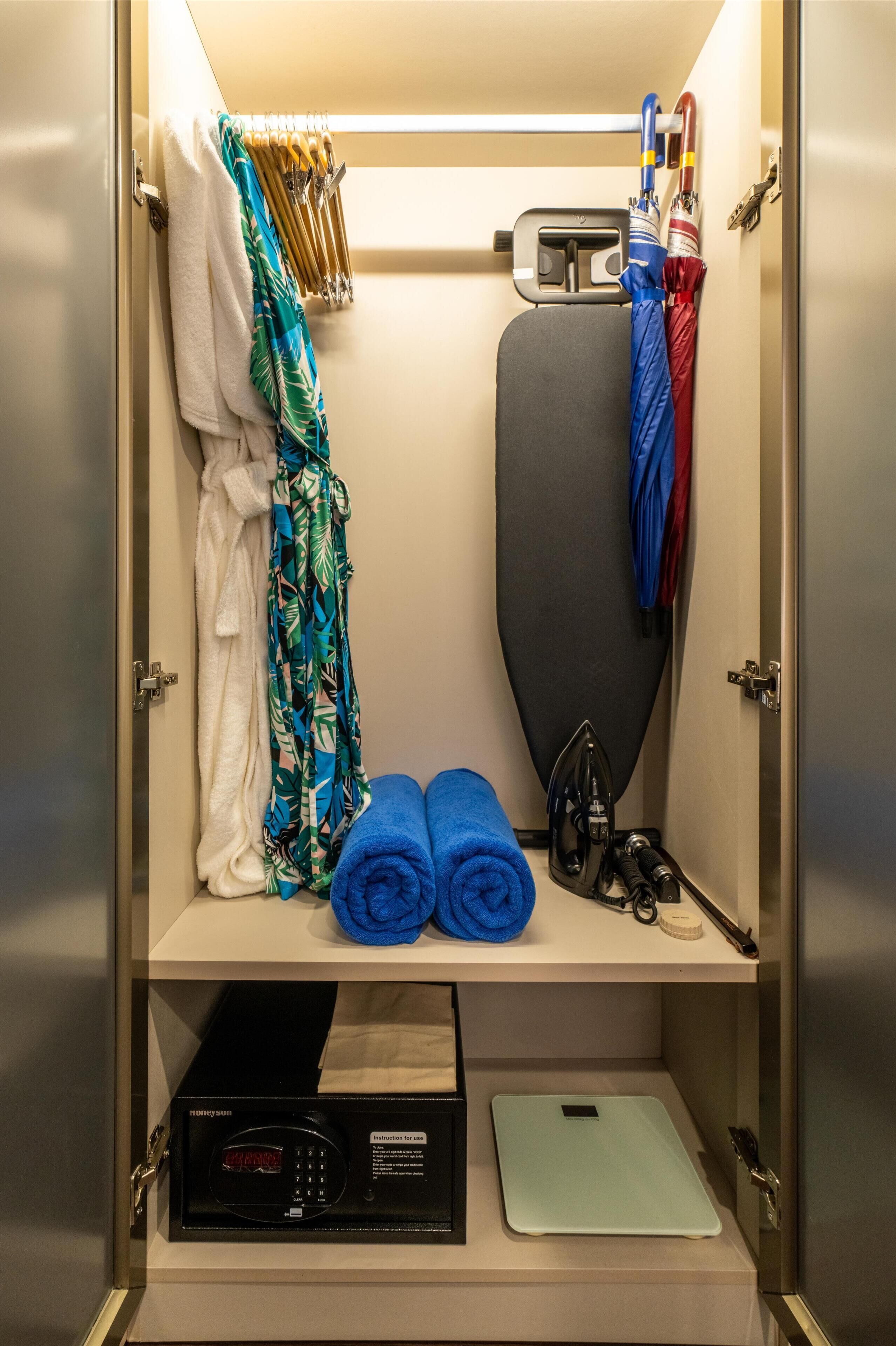 A compact storage unit with a microwave, iron, and iron board.