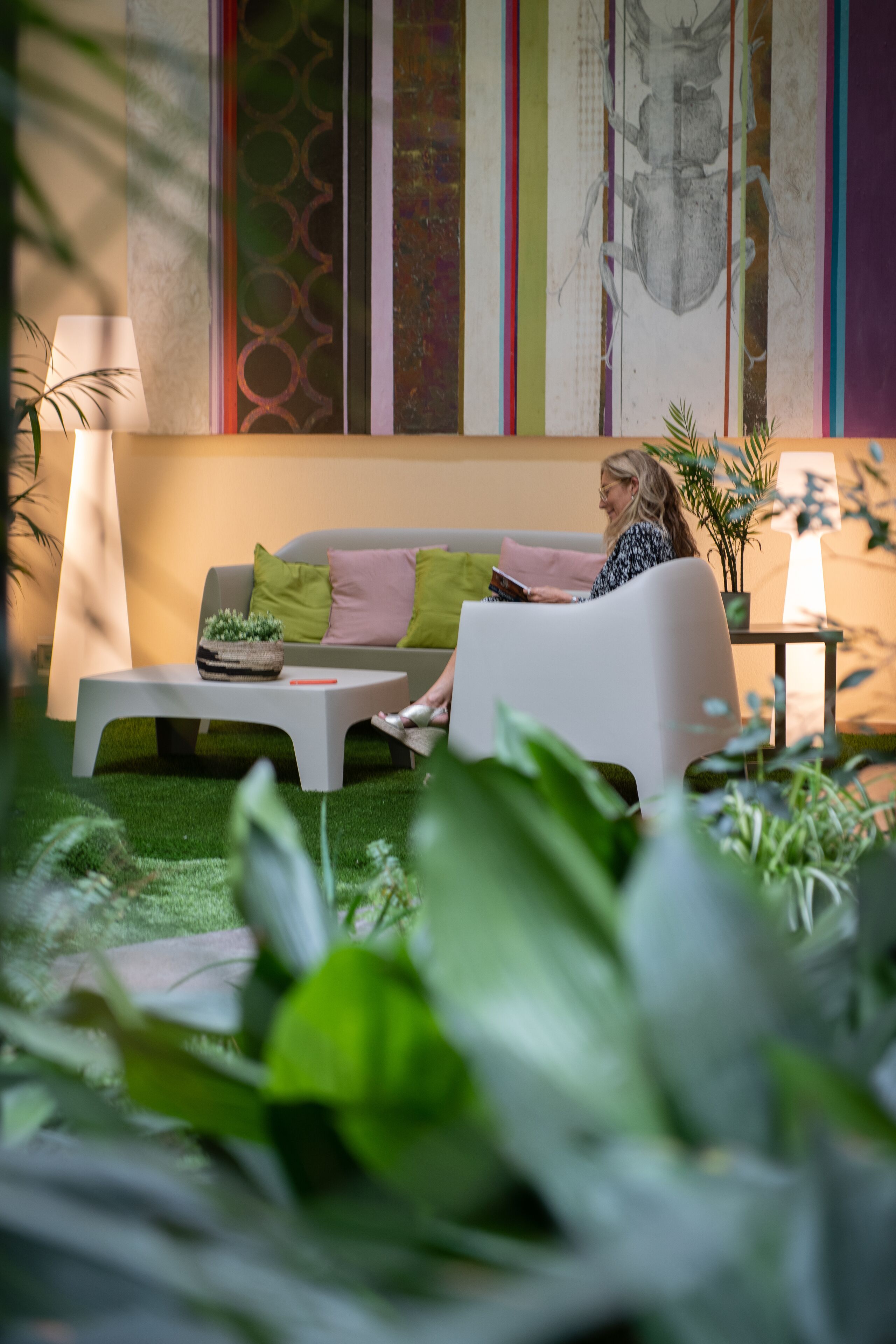 A modern living room with a sofa, a coffee table, and a potted plant.