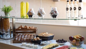 Un buffet de petit-déjeuner proposant des viennoiseries, des fruits et des boissons.