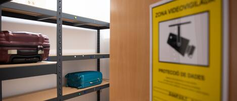 A storage area with metal shelves, a wooden door, and a yellow sign with a black and white warning symbol.