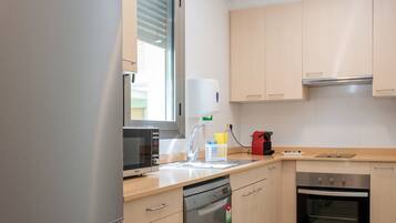 Una cocina moderna con electrodomésticos de acero inoxidable, armarios de madera y lavavajillas.